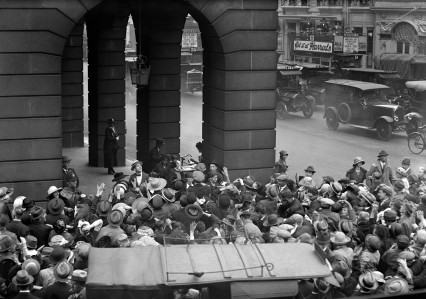 Chaplin throwing carnations to the crowd from his balcony at the Ritz Hotel.