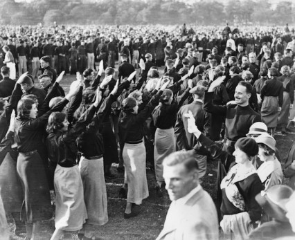 9th September 1934:  Sir Oswald Mosley acknowledging fascist salutes from female members of the British Union of Fascists at an evening demonstration in Hyde Park.