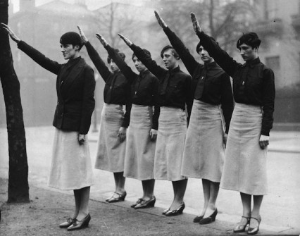 Women 'black-shirts'  from Sir Oswald Mosley's British Union of Fascists on parade give the fascist salute. Their uniform is a black shirt and tie, beret and slightly flared grey skirts. 