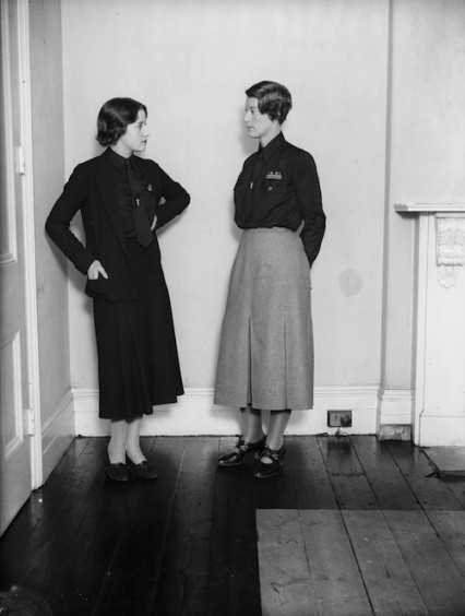 November 1933:  Mrs Swire a leading figure in the women's section of the British Union of Fascists wears the new uniform of grey skirt with black shirt talks to a member of the HQ staff in London who wear all black. Mosley was afraid the women members might jokily be called the 'black skirts'. 